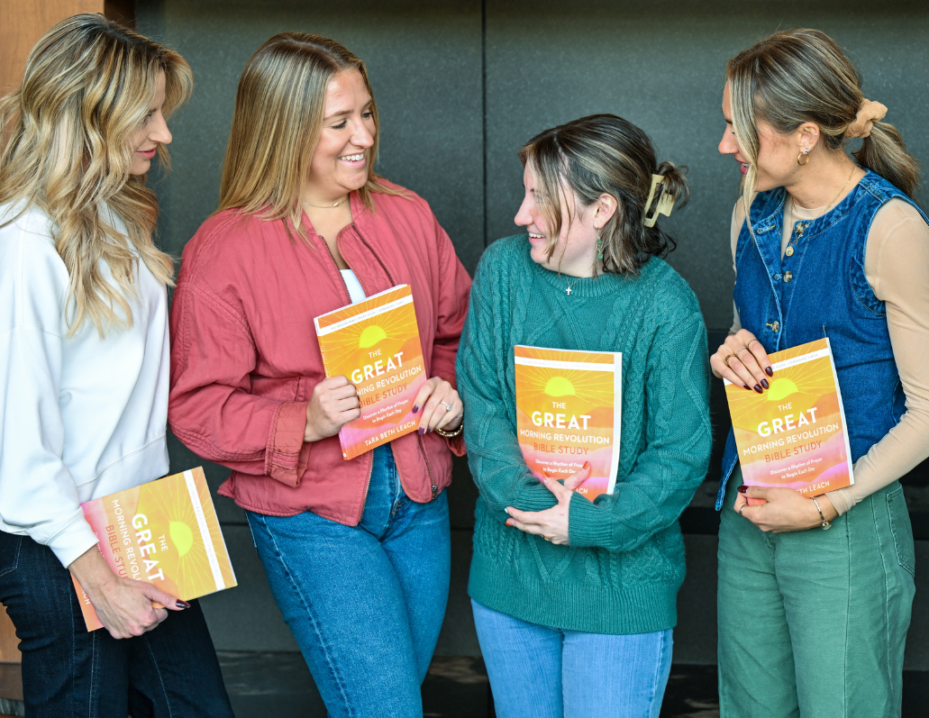 women holding the great morning revolution bible study guide and smiling