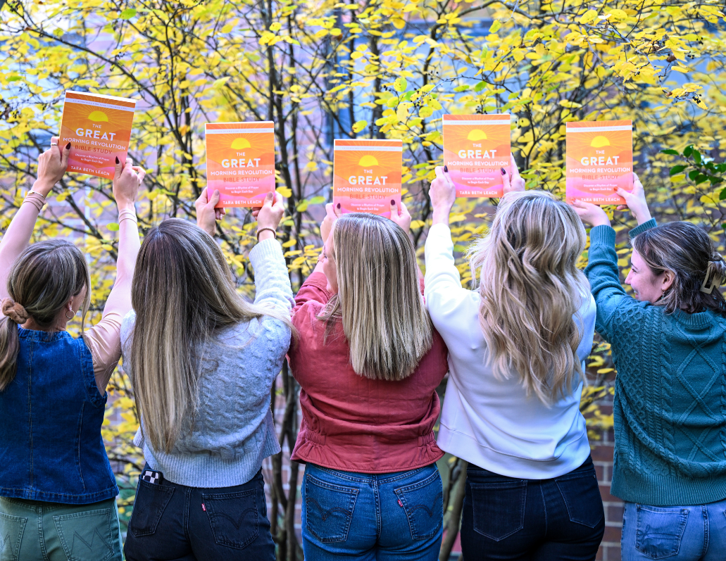 women holding up the great morning revolution bible study guide